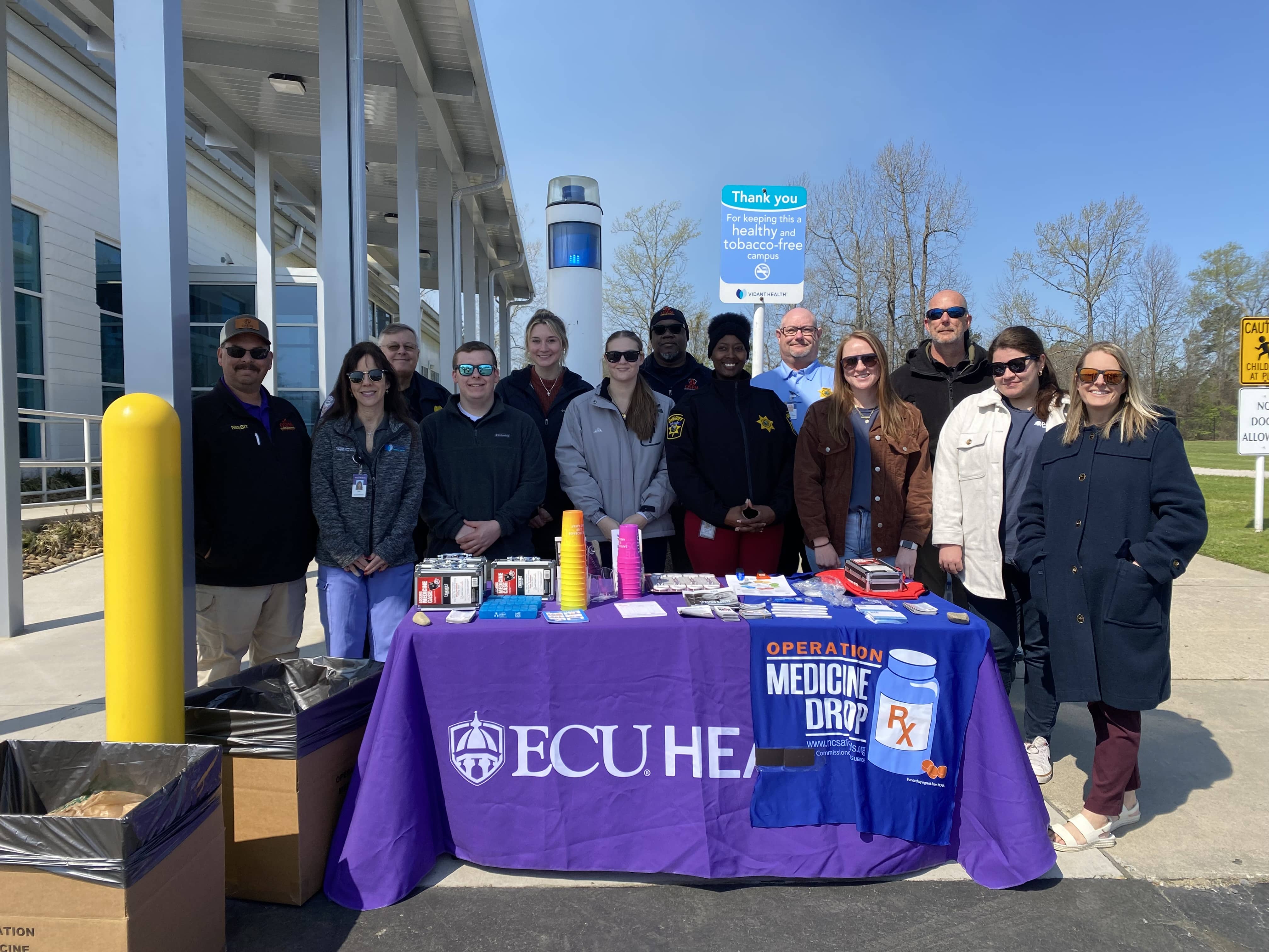 ECU Health team members, along with community partners, pose for a photo during Operation Medicine Drop, an event where the public can dispose of expired, unused, or unwanted prescription drugs or over-the-counter medications.