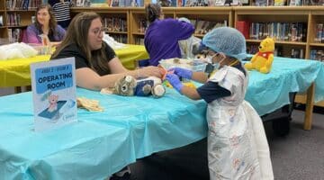 A local student with Pactolus Global School works on her stuffed animal during the Teddy Bear Hospital event.