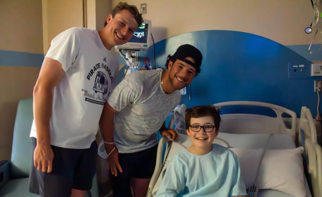 ECU baseball players Carter Cunningham and Parker Byrd visit with a pediatric patient at Maynard Children's Hospital.