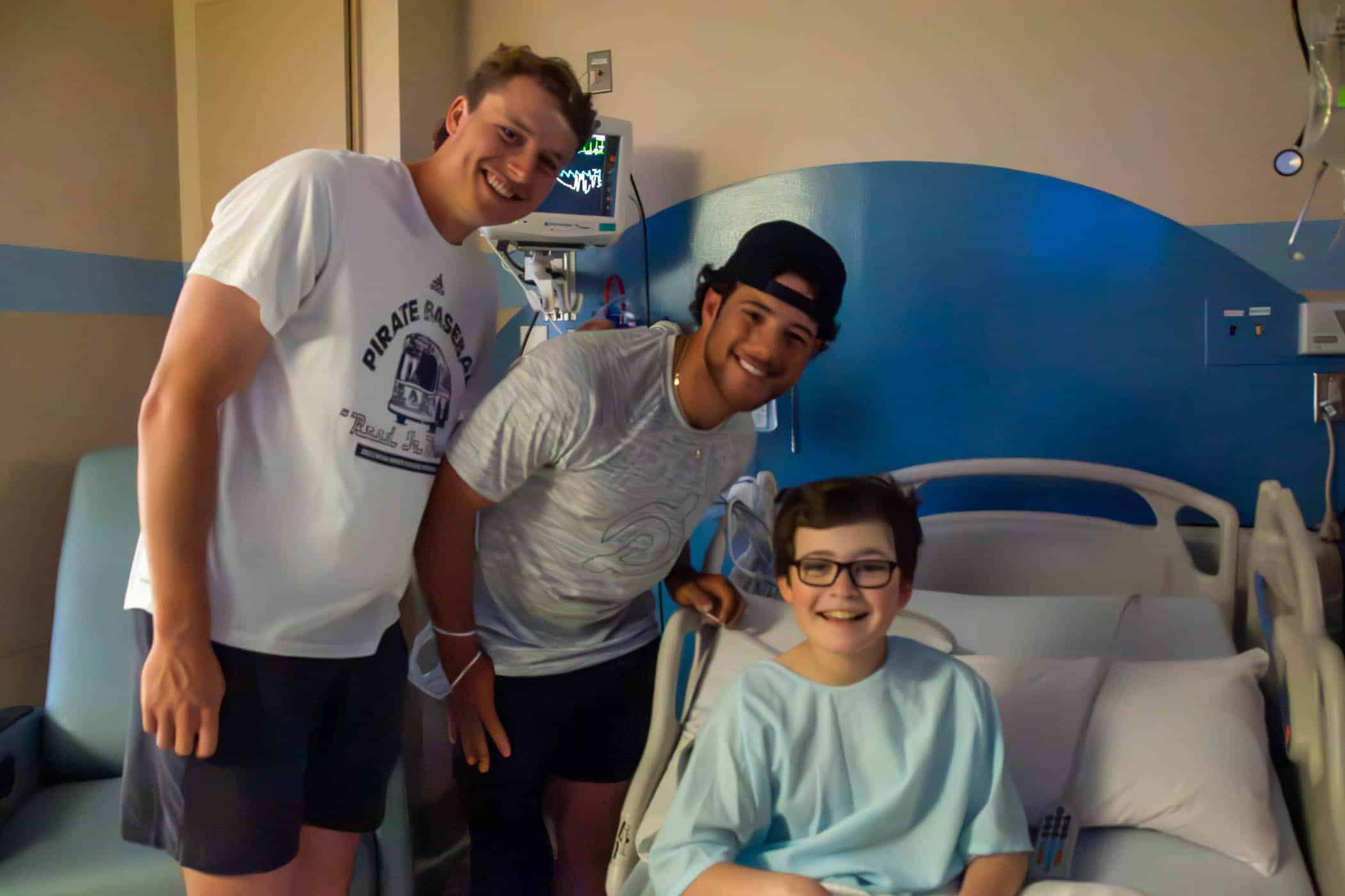 ECU baseball players Carter Cunningham and Parker Byrd visit with a pediatric patient at Maynard Children's Hospital.