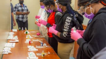 Pitt County students work on a mock lab exercise to place medicine into an IV bag during a Grow Local event at ECU Health Medical Center.