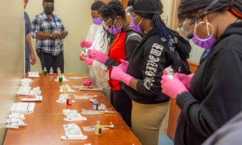 Pitt County students work on a mock lab exercise to place medicine into an IV bag during a Grow Local event at ECU Health Medical Center.