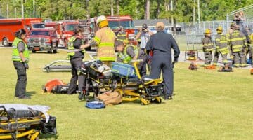 EMS personnel work on a mock patient during a Prom Promise event, designed to inform students about the dangers of drugs and alcohol.