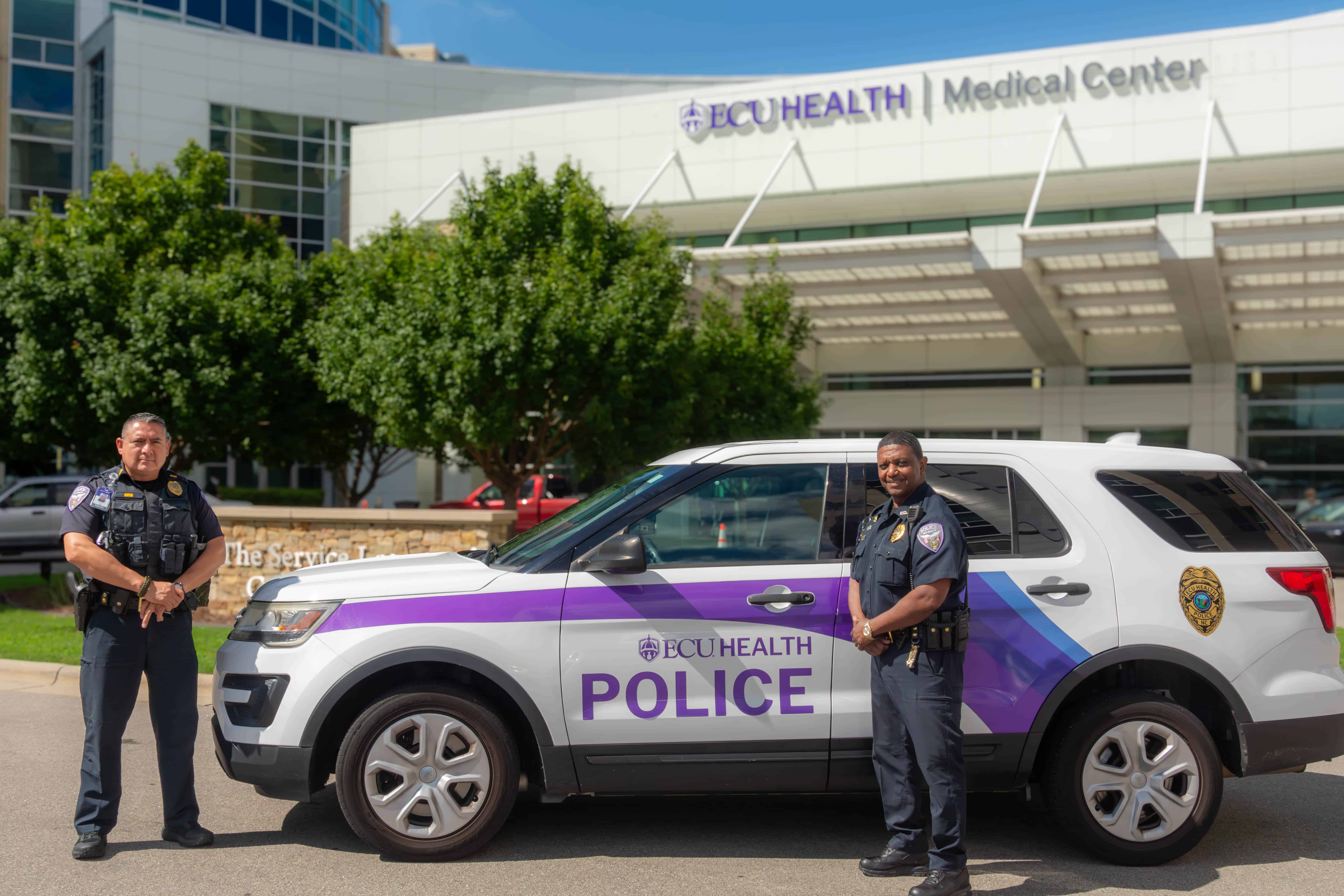 PoliceCars-0011 Two ECU Health Police officers stand by an ECU Health Police Department SUV in front of ECU Health Medical Center.