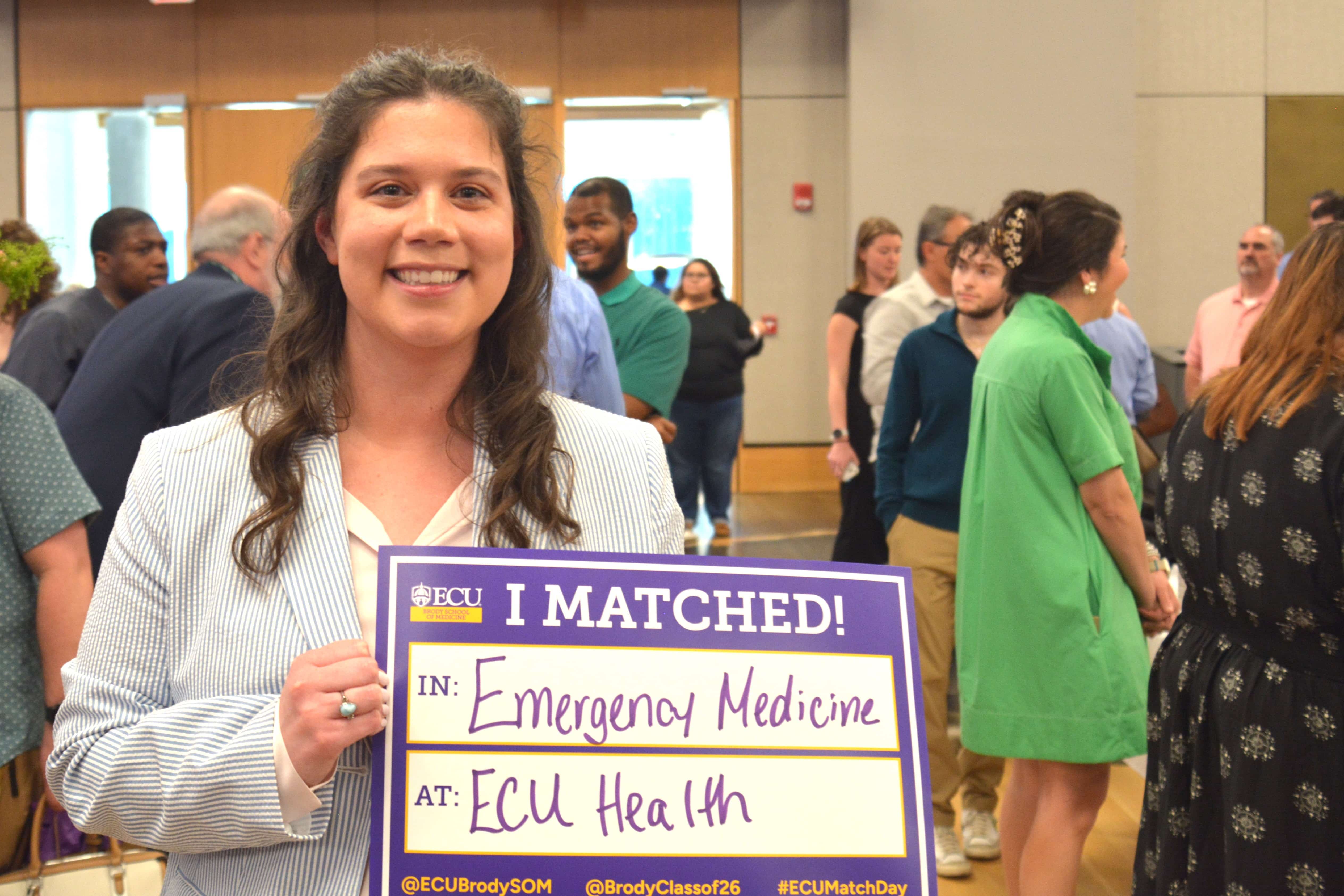 Emily Tate holds her match day sign, showing she matched at ECU Health in Emergency Medicine.