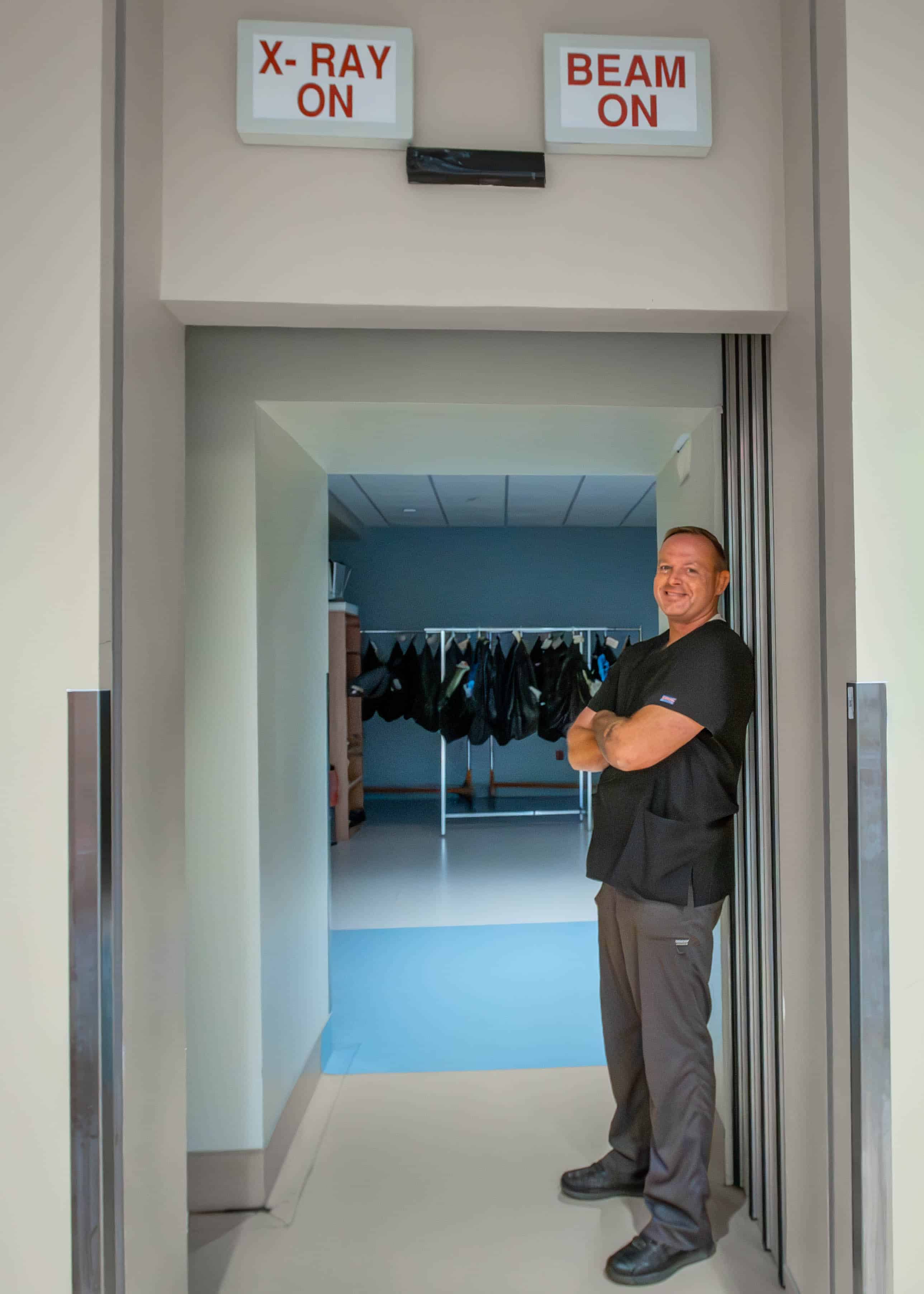 Tim Barnes stands in the hall of radiation oncology at ECU Health Medical Center.