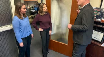 Clinical Psychologist Dr. Samuel Sears and doctoral degree candidates Elizabeth Jordan and Maeve Sargeant talk in an office.