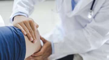 An orthopedic doctor examines a patient's knee.